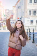 Young attractive playful tourist is making selfie on the phone