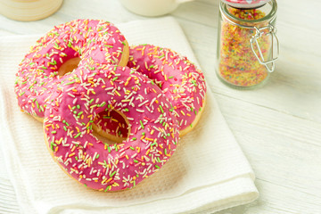 Donut on a kitchen towel and on a wooden table. Photo of sweets.