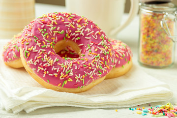 Donut on a kitchen towel and on a wooden table. Photo of sweets.