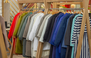 multi-colored winter clothes, down jackets on a hanger