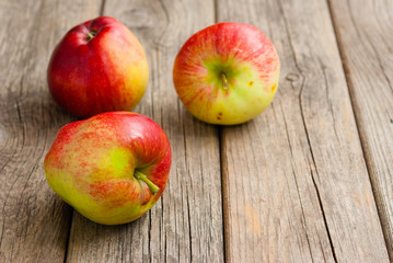 Naklejka na ściany i meble three apples on old wooden background