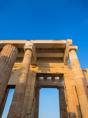 Fototapeta premium Columns of Propylaea entrance gateway of Acropolis, Athens, Greece overlooking the sunset and the city