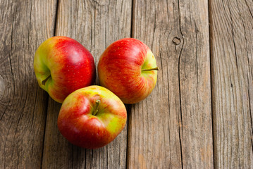 three apples on old wooden background