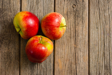 three apples on old wooden background