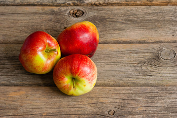 three apples on old wooden background