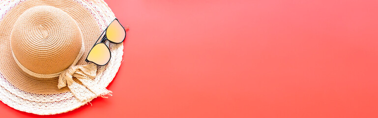 summer concept from sunglasses and straw beach hat flat lay on red background pastel color for...
