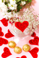 Fototapeta na wymiar heart in a glass, flowers and candy
