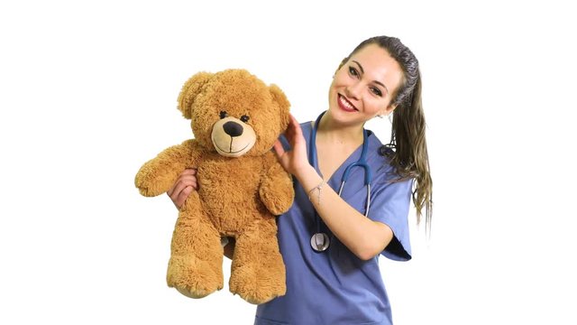 Beautiful nurse holding a teddy bear, pediatrician concept