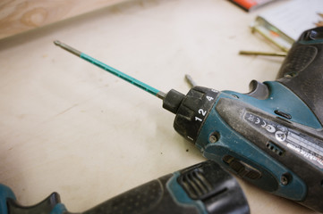 Drill lies on a wooden table in the workshop