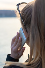 The BeautifulYoung Woman is Talking on Phone with View on the City.