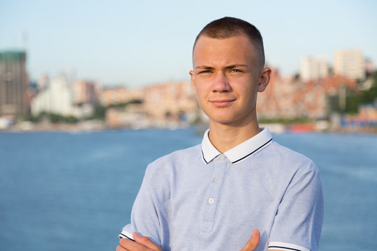 Portrait of a young guy on the background of the sea and city