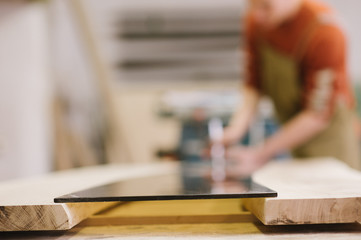 The master works on a surface grinding machine in the carpentry workshop
