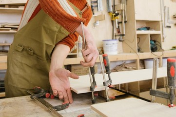 The master works on a surface grinding machine in the carpentry workshop