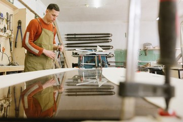 The master works on a surface grinding machine in the carpentry workshop