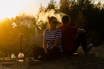 Young couple smoking hookah on the beach
