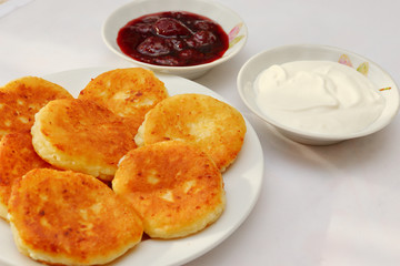 Fragrant ruddy golden with a brown crust freshly cooked syrup curds(cheesecake) with strawberry jam and sour cream piping hot.