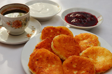 Fragrant ruddy golden with a brown crust freshly cooked syrup curds(cheesecake) with strawberry jam and sour cream piping hot.