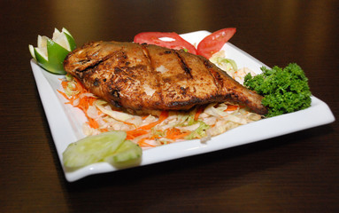 fat fish with salad and some vegetables on the white plate