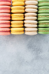 Colorful french macarons on a gray background. Top view.