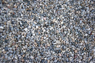 Small gray river stones background, simplicity texture in daylight, group of color stones