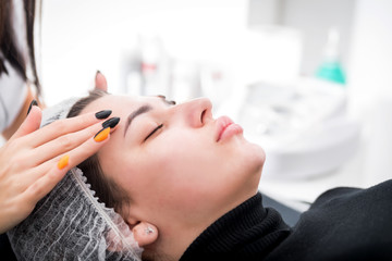 Naklejka premium Beautician applying facial mask at cosmetic clinic, cosmetology treatment skincare face