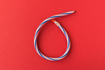 Fototapeta premium Flexible pencil . Isolated on red background. Bending pencil.