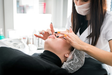 Beautician applying facial mask at cosmetic clinic, cosmetology treatment skincare face