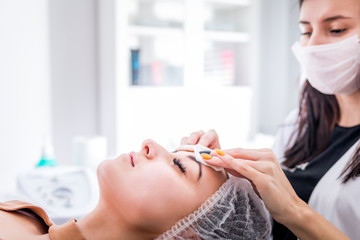 Beautician cleanses skin woman with sponge in spa beauty salon. cosmetology treatment skincare face