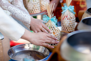 Offer food to monk. Groom give alms food to a Buddhist monk in traditional thai wedding ceremony. Hand while put food offerings in a Buddhist monk's alms bowl.Buddhists offer food in bowls.