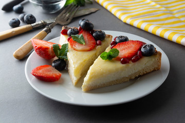 Cheesecake with fresh berries and mint for dessert - healthy organic summer dessert pie cheesecake. Cheese cake. Gray background.