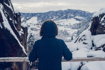 The figure of a traveller ascending to a mountain summit against the background of a snow-covered...