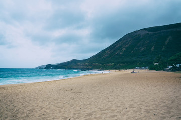 Fototapeta na wymiar Oahu beach with big waves and many people on sand