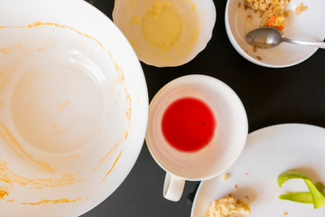lots of dirty white dish plates and cups on the table after meal