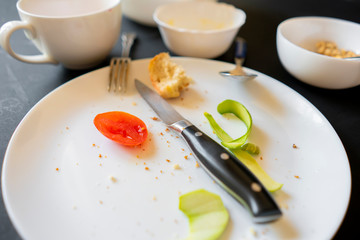 lots of dirty white dish plates and cups on the table after meal
