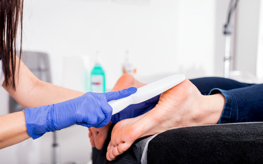 Obraz premium Peeling feet pedicure procedure at cosmetic salon
