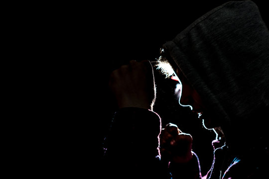 silhouette of male fighter in the hood in the darkness
