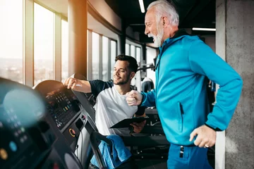 Poster Senior and young sportsmen exercising at gym. © hedgehog94