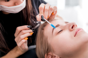 Pretty girl getting brow depilation at beauty salon