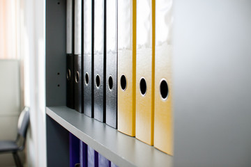 colorful archive folders for documents on the shelves in the office - obrazy, fototapety, plakaty