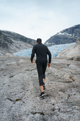 portrait of young traveler rock climber on the background of spellbinding landscape of Norwegian nature with high charming mountains and hills