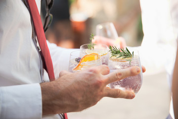 carrying a trio of gin cocktails at a formal celebration
