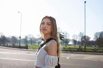 Teenage girl walking on the pavement with a road behind her