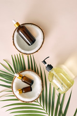 Fototapeta premium Cracked coconut and a bottle of oil on the table - spa, skincare, haircare and relaxation concept