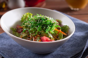 Traditional Japanese salad. With seaweed, fresh herbs, tomatoes, cucumbers, carrots, sesame