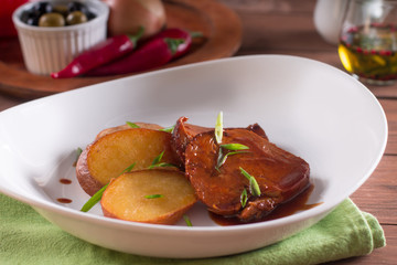 Fried potatoes and meat slices in sauce, simple country dish
