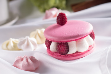 Pink macarons with vanilla cream, fresh raspberries