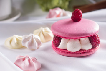 Pink macarons with vanilla cream, fresh raspberries