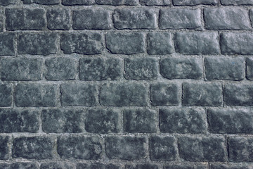 Paving stone texture, cobblestone road. Smooth, time-polished stone, black.