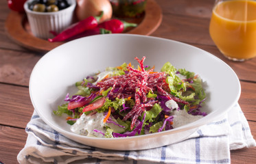 Mediterranean cuisine. Fresh salad with arugula, tomatoes, red cabbage, cucumber and yogurt sauce