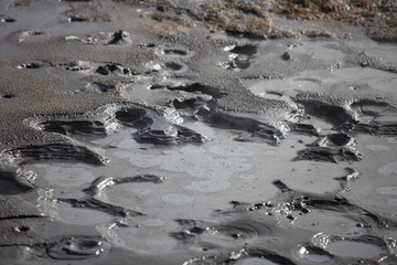 Iceland geothermal zone Namafjall - area in field of Hverir. Closeup photo of pools with boiling mud. Tourist and natural attractions.